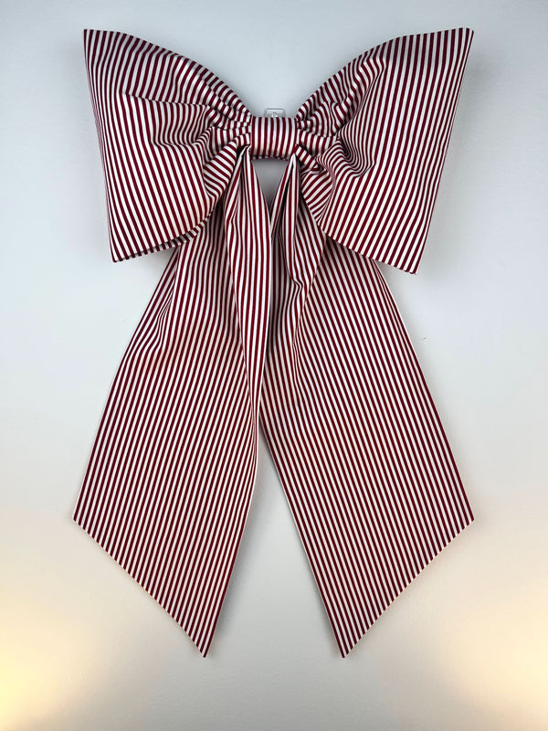 Red and white striped bow on a light gray background