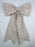 Brown and white striped bow on a light gray background