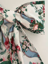 Floral and paisley patterned fabric with a bow on a white background