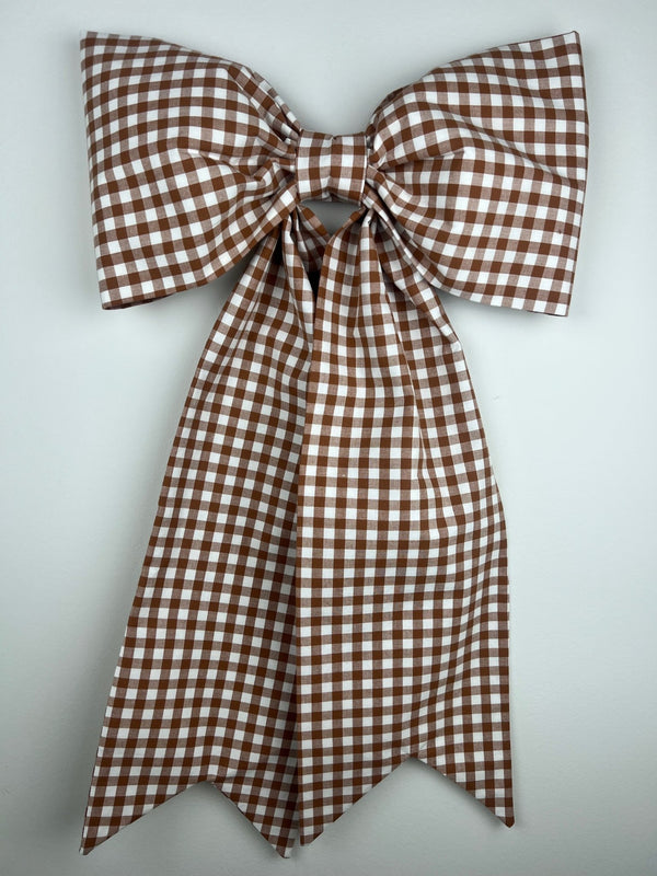 Brown and white checkered bow on a light gray background