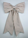 Brown and white striped bow on a light gray background