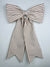 Brown and white striped bow on a light gray background